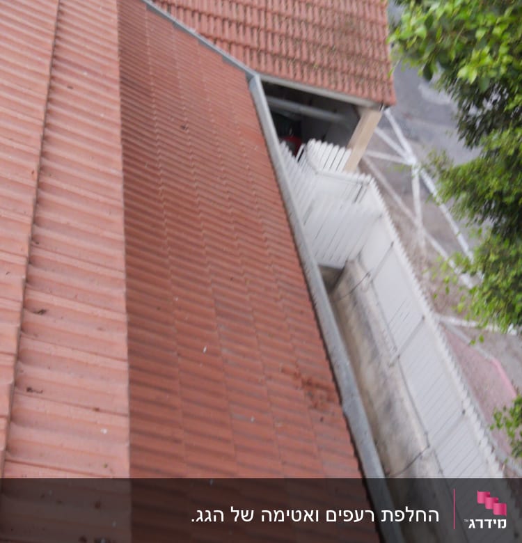 גג רעפים אדום עם מרזב מתכת בצד